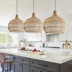 three lights hanging over a kitchen island