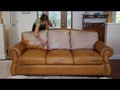 a woman cleaning a leather couch in a living room