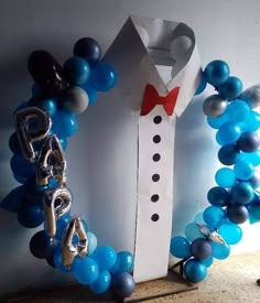 the balloon arch is made to look like a man's tuxedo suit