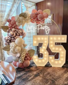 balloons and lights are arranged in the shape of numbers for a 50th birthday party at home