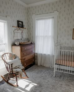 a baby's room with a rocking chair, crib and dresser in it