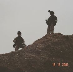 two soldiers standing on top of a hill