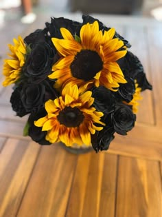 a vase filled with black and yellow flowers