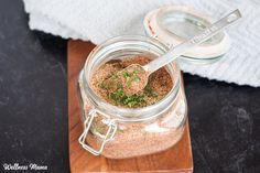 a jar filled with spices sitting on top of a wooden cutting board