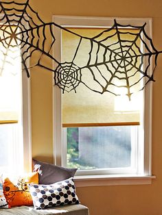 the window is decorated with spider webs and other decorations for halloween time, as well as an easy diy project