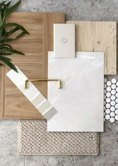 some tile and wood are laying out on the floor next to a potted plant