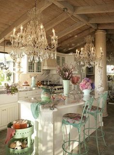 a kitchen filled with lots of counter top space next to a chandelier hanging from the ceiling