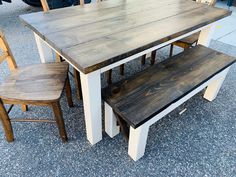 a wooden table with two benches next to it on the ground in front of other tables and chairs