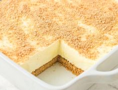 a cake in a white dish with some crumbs on top