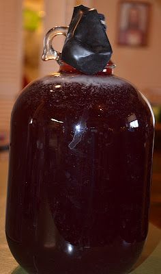 a large brown jug with a black plastic cap on it's top sitting on a table