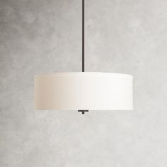 a white lamp hanging from a ceiling in a room with concrete walls and flooring