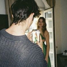 a woman is taking a photo of herself in the mirror with her cell phone while another woman looks on