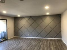 an empty room with wood floors and gray walls