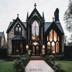 the entrance to a gothic - style house lit up at night with lights shining on it's windows