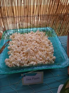 a glass bowl filled with popcorn sitting on top of a blue tablecloth covered table