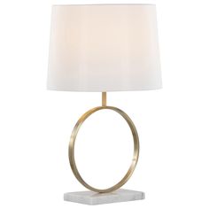 a table lamp with a white shade on the base and a gold ring around it