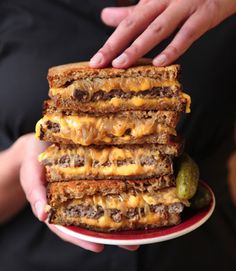 a stack of cheeseburger sandwiches sitting on top of a red plate