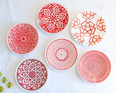 four red and white plates sitting on top of a table