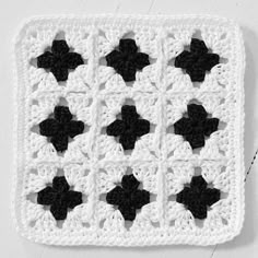 a crocheted square with black and white flowers