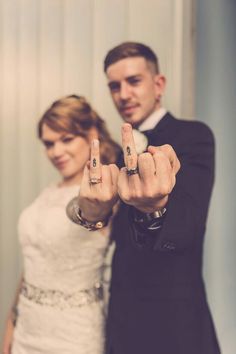 a man and woman posing for the camera with their fingers in the shape of numbers