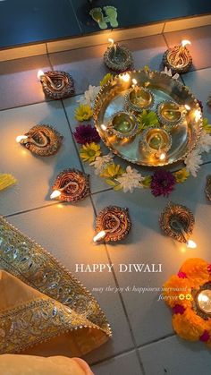 an arrangement of diyas and candles on the floor