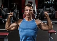 a man is holding two dumbs in front of his face and looking at the camera