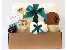 a gift box filled with items such as candles, blankets and other holiday gifts for someone special