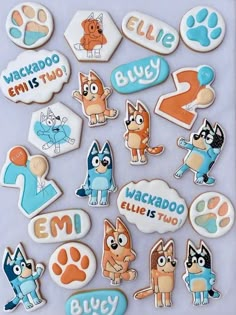 an assortment of decorated cookies in the shape of dogs and cats with name tags on them