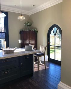 a kitchen with wooden floors and an arched doorway leading to the back door is shown