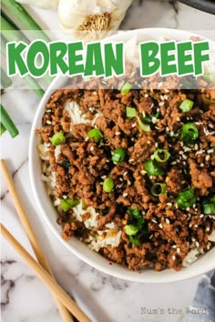 korean beef rice in a white bowl with chopsticks and garlic on the side