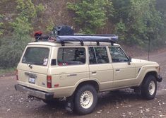 an suv parked on the side of a dirt road