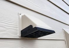 an air conditioner mounted on the side of a house's exterior sidings