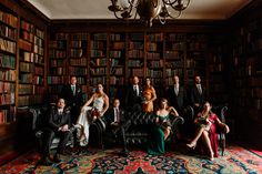 a group of people sitting on top of a couch in front of a bookshelf