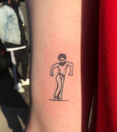 a person with a small tattoo on their arm that has a man holding a baseball bat