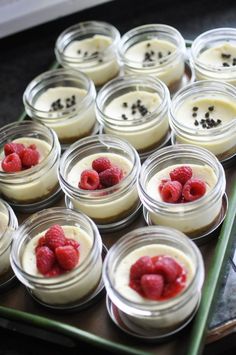 small desserts with raspberries in glass jars on a tray