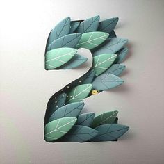 the letter s is made out of paper and has leaves on it's sides