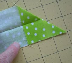 someone is cutting out the fabric for a green and white polka dot ornament