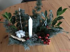 a wooden table topped with a candle and christmas decorations