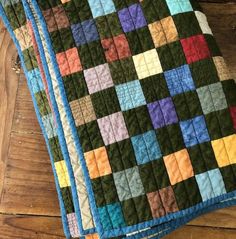 three quilts that are sitting on the floor next to each other and one is multicolored