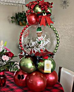 a christmas tree made out of balloons and ornaments on top of a dining room table