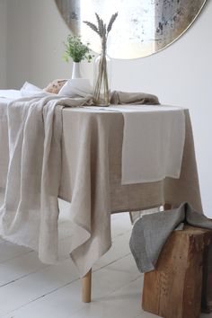 a table with a white cloth on it and a vase full of flowers in the middle