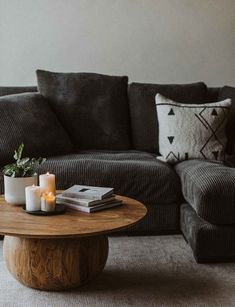 a living room with a couch, coffee table and two candles on top of it