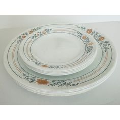 three plates are stacked on top of each other, one has an orange flower design