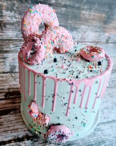 a frosted cake with sprinkles and doughnuts on the top