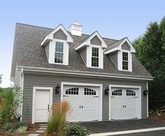 a two car garage with three windows on the top floor and one above the door