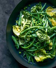 a bowl filled with green vegetables and peas