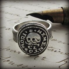 A stunning skull wax seal ring with a wonderful Latin motto "Memento Mori", translated to "Remember your Mortality" or "Remember that you must die", a reminder to live life well. The phrase Memento Mori is a symbolic reminder of the inevitability of death and was first used in the late 1500's. We created the ring band to include vintage lines of prose from an old letter running across it, a perfect compliment to the seal. You may also select a plain ring band at checkout. Each ring is cast using Wax Seal Ring, Memento Mori Ring, Latin Mottos, Meaningful Rings, Old Letters, Casual Rings, Plain Rings, Seal Ring, Jewels Rings