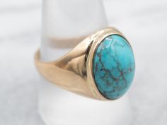 This stylish yellow gold ring features a bezel set turquoise stone, beautifully crafted to add an elegant detail to any outfit. Its simple design ensures that it will be a favorite for years to come.Metal: 14K Yellow Gold Gem: Turquoise 6.31 CaratsGem Measurements: 11.5 x 15.4 mm, OvalRing Size: 10Marks: "ADM 14K" Stamped on the inside band Pocket Watch Chain, Watch Chain, Yellow Gold Ring, Pearl Pendant, Turquoise Stone, Bezel Setting, Charm Earrings, Yellow Gold Rings, Solitaire Ring