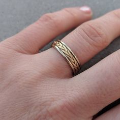 a person's hand with a gold ring on their left hand, wearing it in the middle