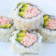 several sushi rolls stacked on top of each other with pink and green toppings